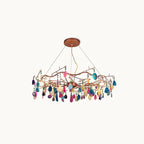 Multicolour Clérachic agate chandelier with rose-gold branches and suspension wires, on a cream backdrop.