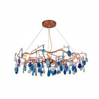 Blue-slice Clérachic agate chandelier on a white backdrop, with light and deep blue stones hanging from rose-gold branches.