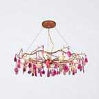 Pink-slice Clérachic agate chandelier on a pale grey backdrop, with magenta and blush stones hanging from the frame.