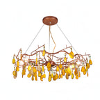 Yellow-slice Clérachic agate chandelier on a white backdrop, with amber stones and green beads on the rose-gold frame.