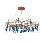 Blue-slice Clérachic agate chandelier on a white backdrop, with navy and light blue stones hanging below the branches.
