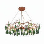 Green-slice Clérachic agate chandelier on a white backdrop, with emerald slices and bulbs lit along the rose-gold frame.