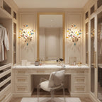 Two Clérachic agate wall lights flank a gold-framed mirror above a dressing table in a cream walk-in wardrobe.