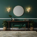 A pair of green-toned Clérachic agate wall lights on a deep green wall, either side of a round mirror above a console.