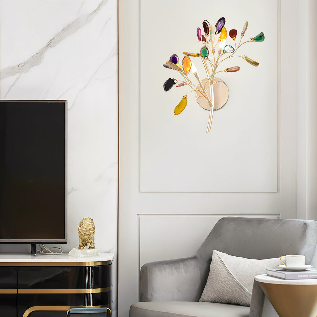 Multicolour Clérachic agate wall light on a panelled wall beside a television, with a grey armchair and marble wall below.