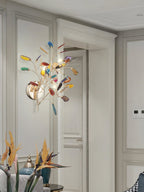 Multicolour Clérachic agate wall light mounted on a pale panelled wall in a hallway, with tall plants at the bottom.