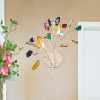 Close view of this Clérachic agate wall light against a warm beige wall, with soft pink flowers blurred at the left.