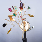 The Clérachic agate wall light photographed on a studio stand against a pale blue backdrop, its wiring visible behind the stems.