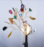 Studio view of the Clérachic agate wall light on a black stand, showing wires and fittings behind the gold stems.