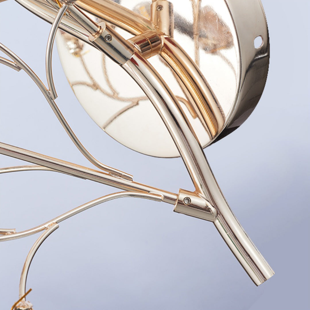 Close view of the gold stems and round back plate of this Clérachic agate wall light, with their metal joints.