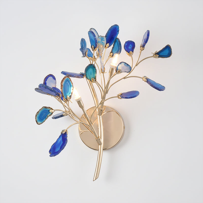 Blue Clérachic agate wall light on a pale wall, with deep blue and aqua stone slices around candle-style bulbs.