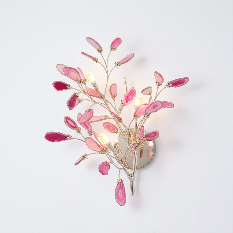 Larger pink Clérachic agate wall light on a white wall, with rose and magenta slices around candle-style bulbs.