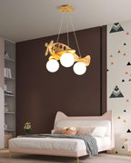 A Clérachic airplane light above a pink bed with a cat-ear headboard, against a brown wall with a triangle pattern.