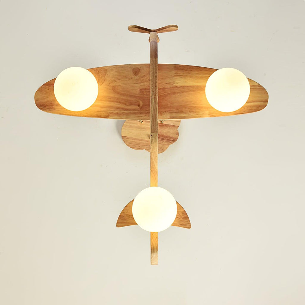 View from below of the Clérachic airplane light, showing its wooden wings, tail and propeller with a round white globe under each wing.