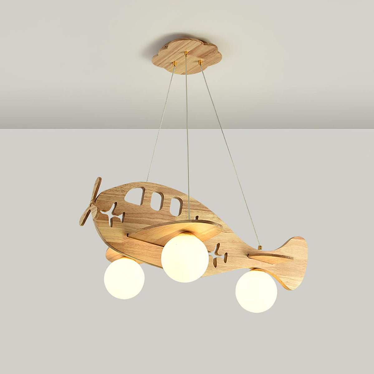 Lit Clérachic airplane light on a light grey backdrop, the three globes giving a warm glow below the wooden wings.