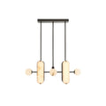 The Clérachic Alabaster 5-Light Linear Island Pendant lit head-on, warm light glowing evenly through both stone capsules and all three globes.