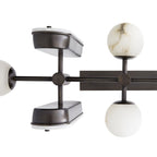 Close detail of the Clérachic Alabaster 5-Light Linear Island Pendant, showing the machined bronze cross joints and grey-veined stone globes.