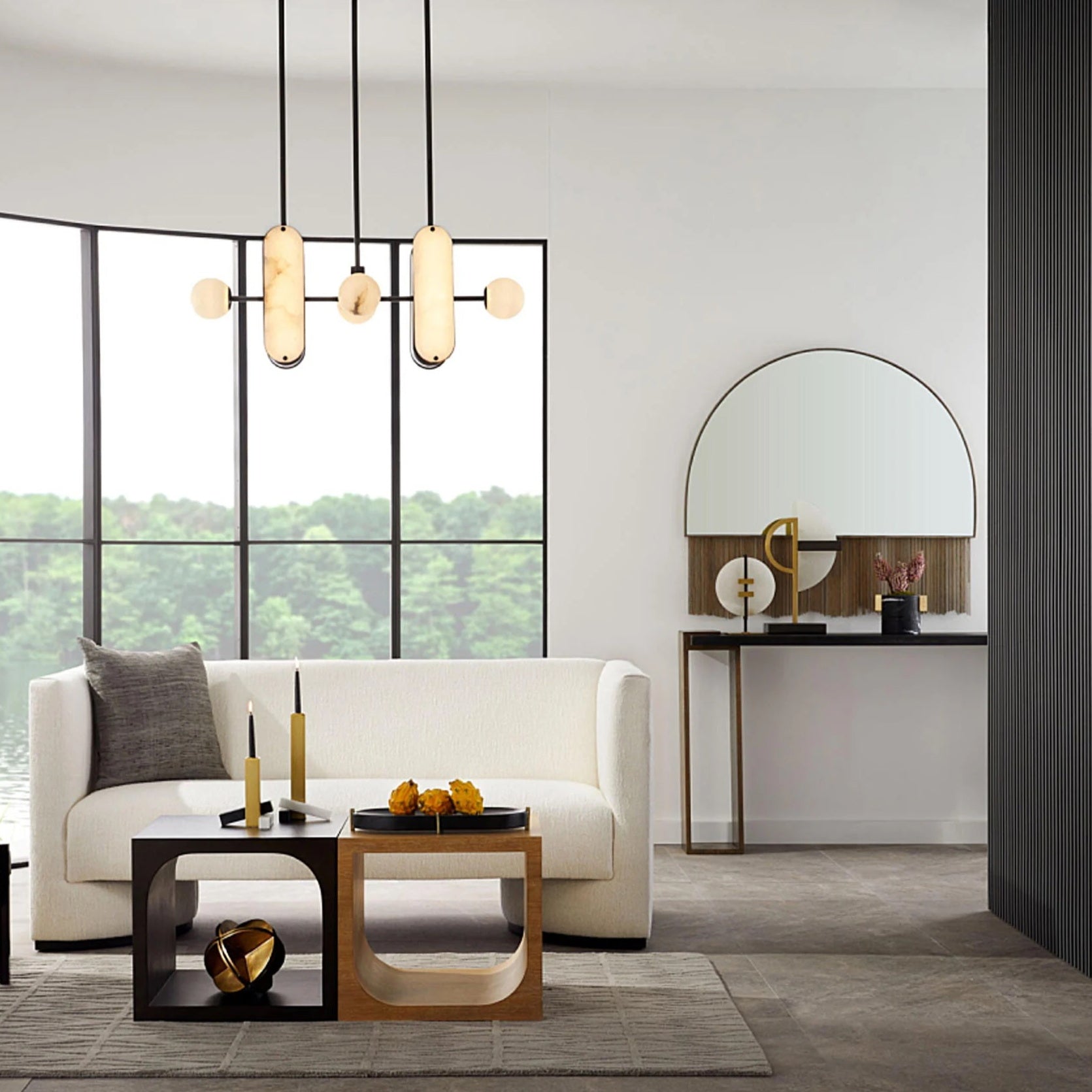 A Clérachic Alabaster 5-Light Linear Island Pendant hanging over a bouclé sofa in a lakeside living room with a curved black-framed window.