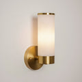 Clérachic Alabaster and Brass Wall Sconce switched on, the stone glowing warm and throwing soft light up the wall.