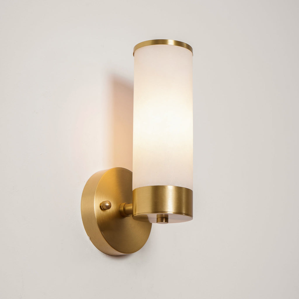 Clérachic Alabaster and Brass Wall Sconce lit from within, the shade even and golden from top ring to brass collar.