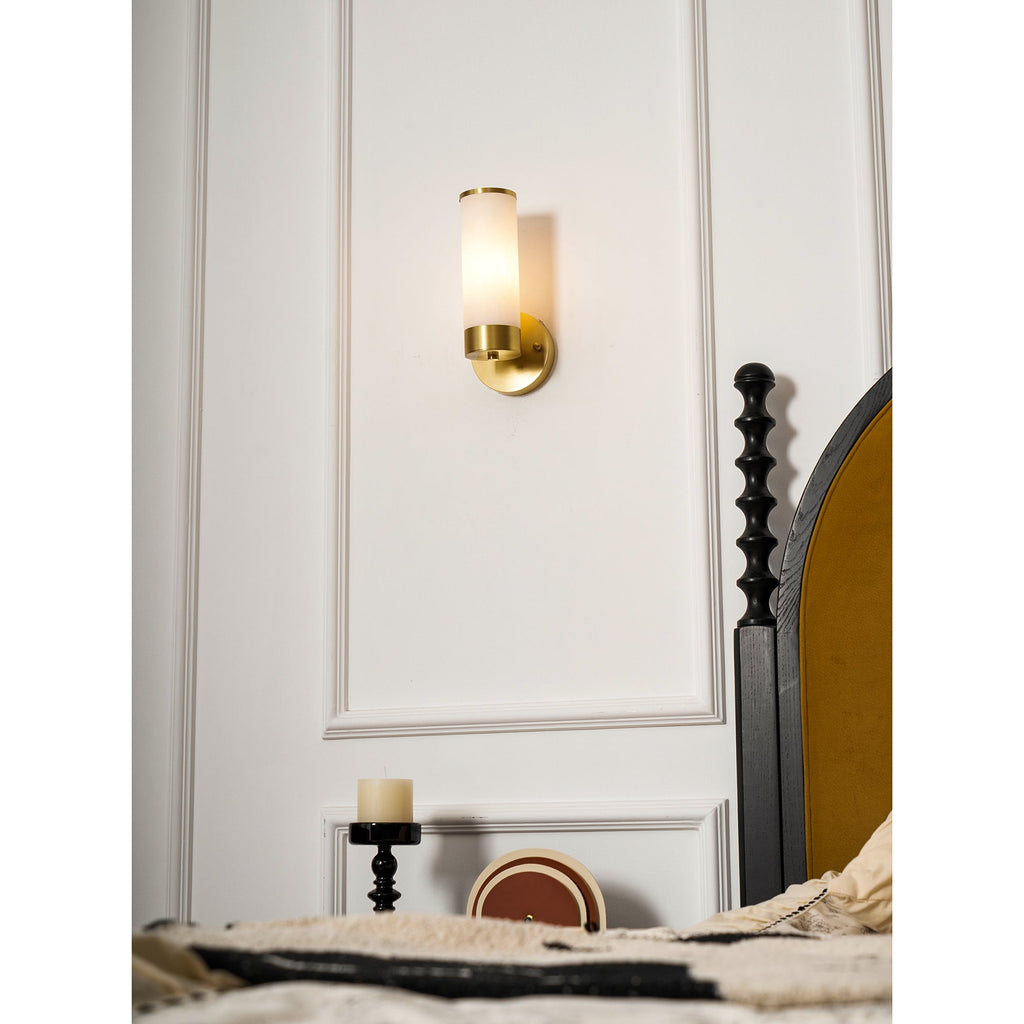 Clérachic Alabaster and Brass Wall Sconce seen from the bed, a single warm light on the panelling by the headboard.