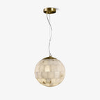 The Clérachic alabaster ball pendant on white, its stone tiles lit warm from inside the globe.
