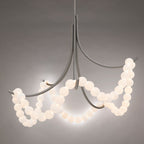 Clérachic Alabaster Bead Chandelier in nickel, lit against grey so the beads glow while the arms stay quiet and cool.