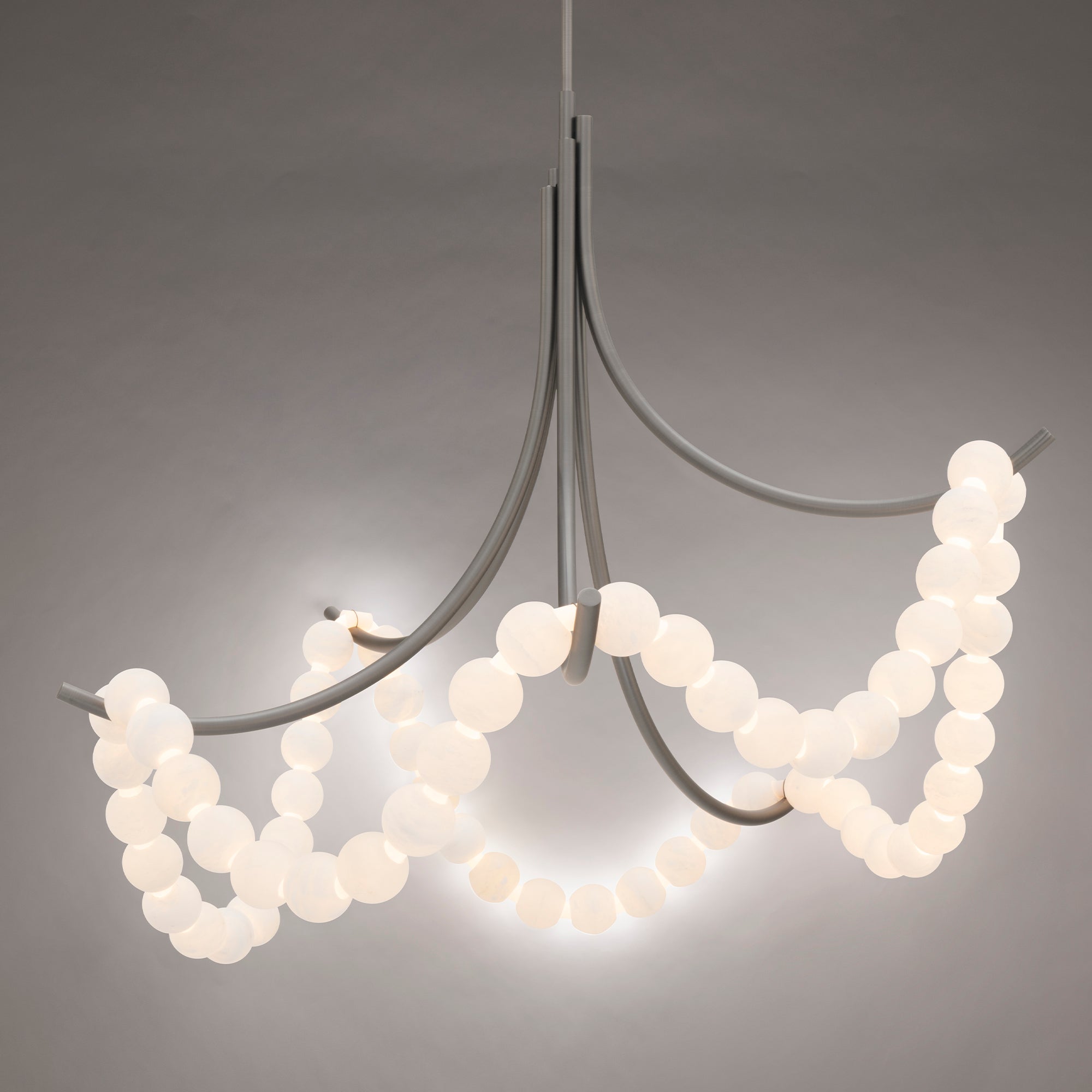 Clérachic Alabaster Bead Chandelier in nickel, lit against grey so the beads glow while the arms stay quiet and cool.