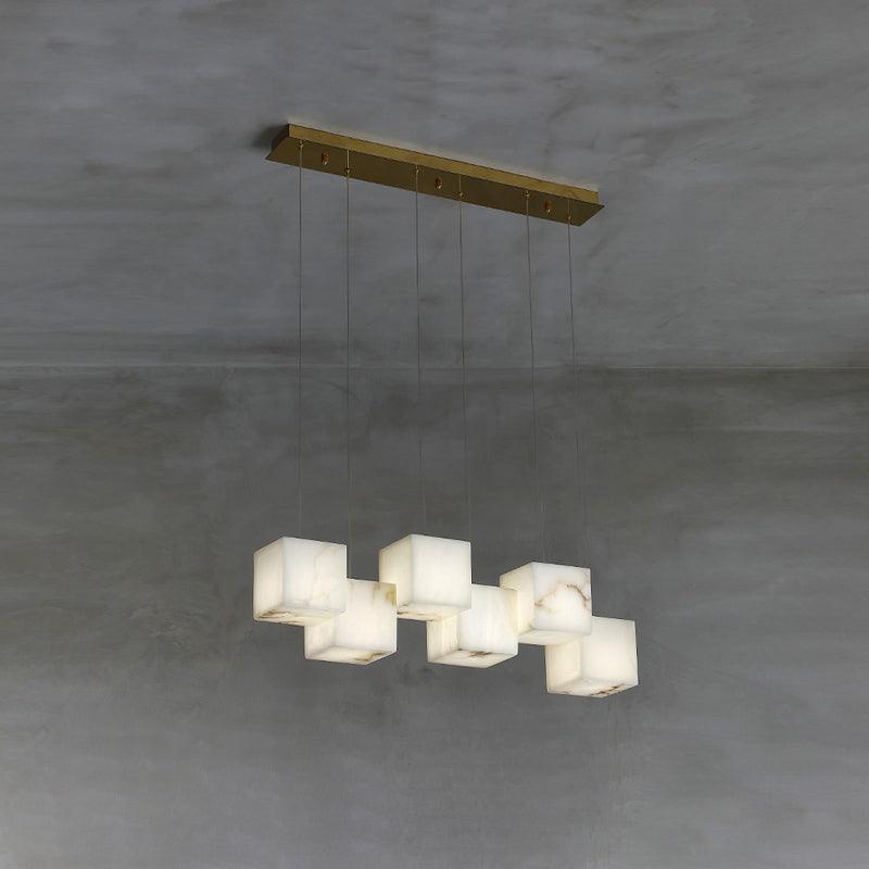 Clérachic alabaster box chandelier, six cube shades hung from a brass bar on concrete.