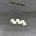 Clérachic alabaster box pendant, six cube shades on cables from a brass ceiling bar.