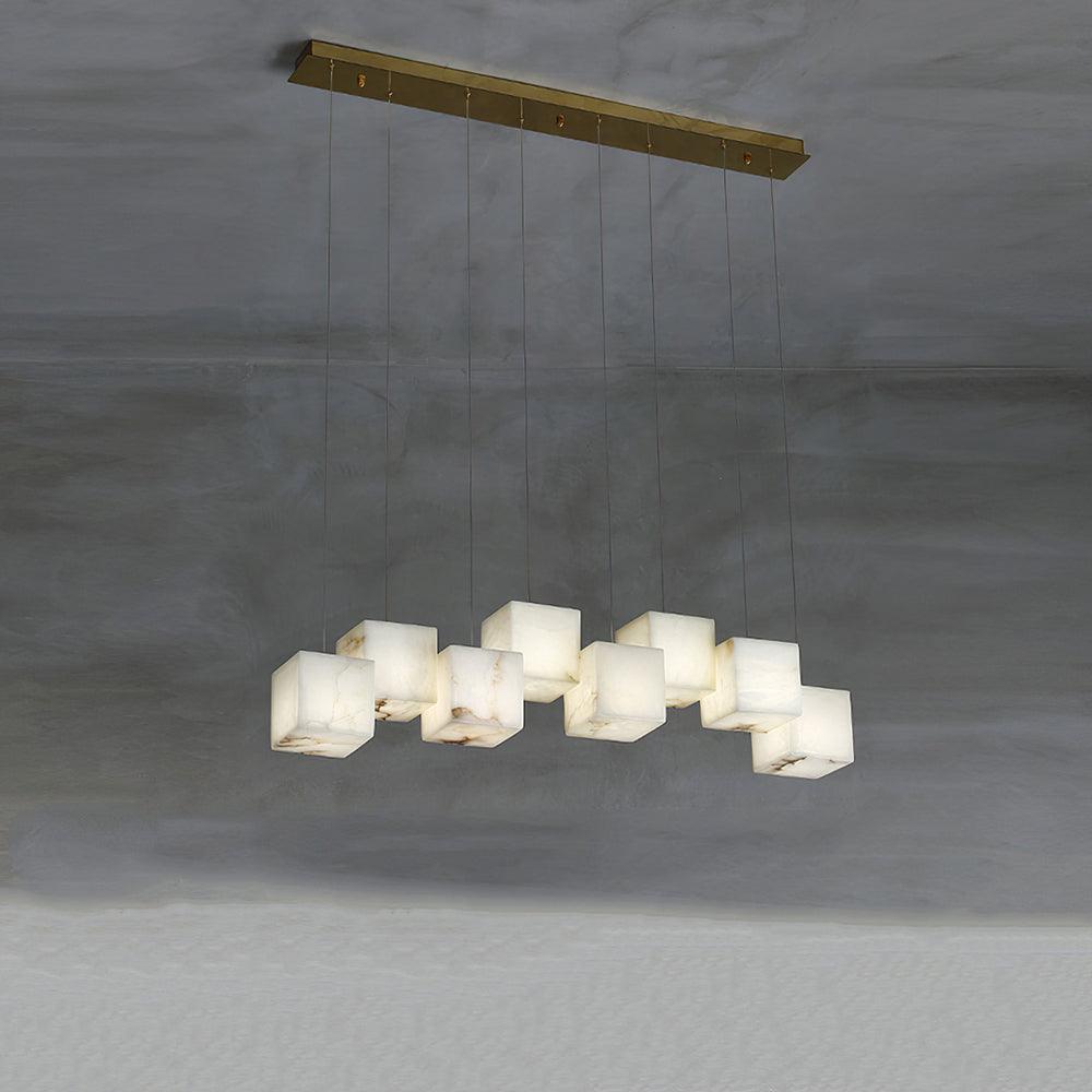 The Clérachic box pendant with ten cubes staggered along a long brass bar on concrete.