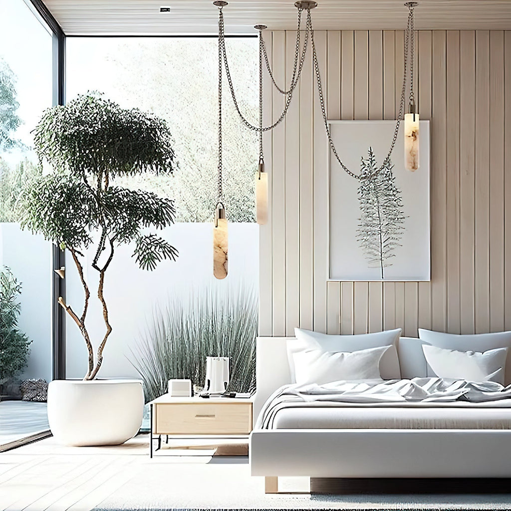 Clérachic Alabaster Capsule Pendant Light hung beside a bed in a bright panelled bedroom, chains swagging above the headboard.