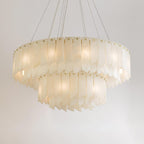 The Clérachic cascade chandelier on white, brass studs pinning each alabaster blade.
