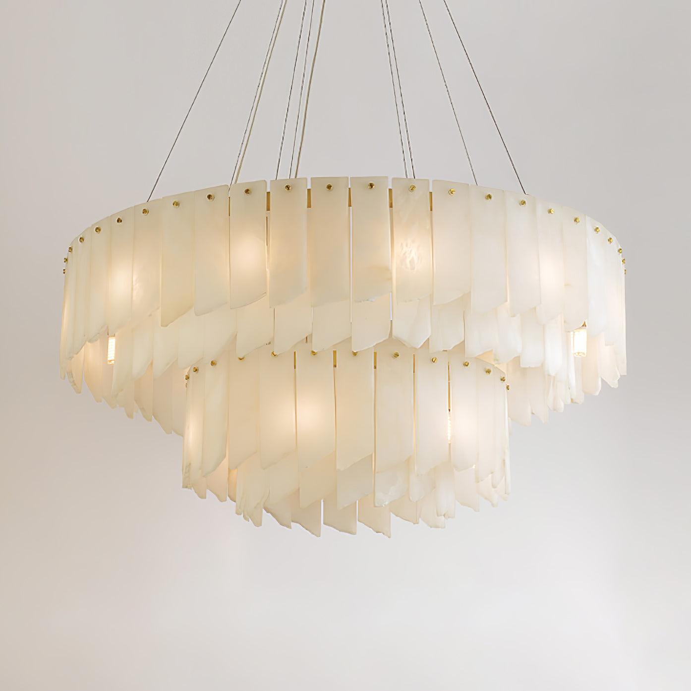 The Clérachic cascade chandelier on white, brass studs pinning each alabaster blade.