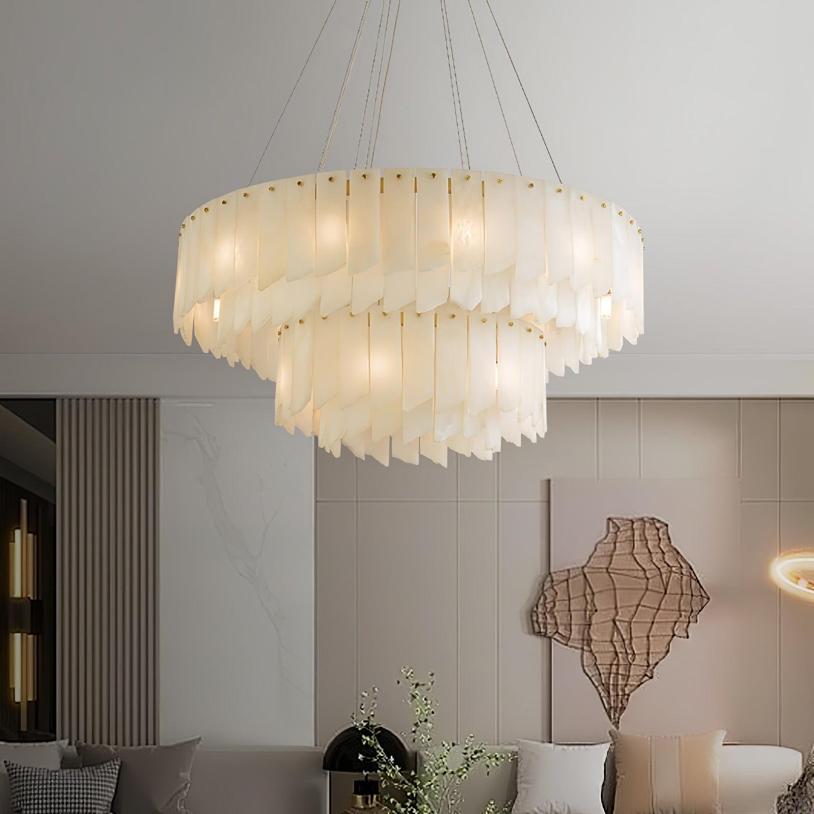 Clérachic cascade chandelier lit above a sofa in a room with a woven wall sculpture.