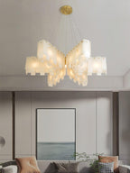 Clérachic cascade chandelier in its widest stepped form, lit above a framed seascape.