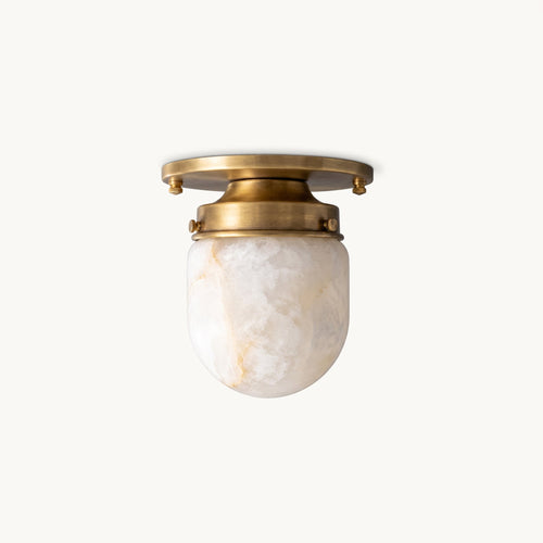 This Clérachic alabaster flush mount on a plain white backdrop, a brass canopy above a veined white stone shade.