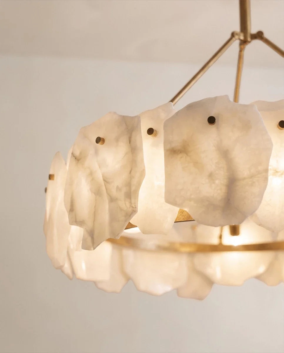 Clérachic chandelier close-up of veined alabaster petals fixed to a brass ring with small round pins, glowing softly from within.