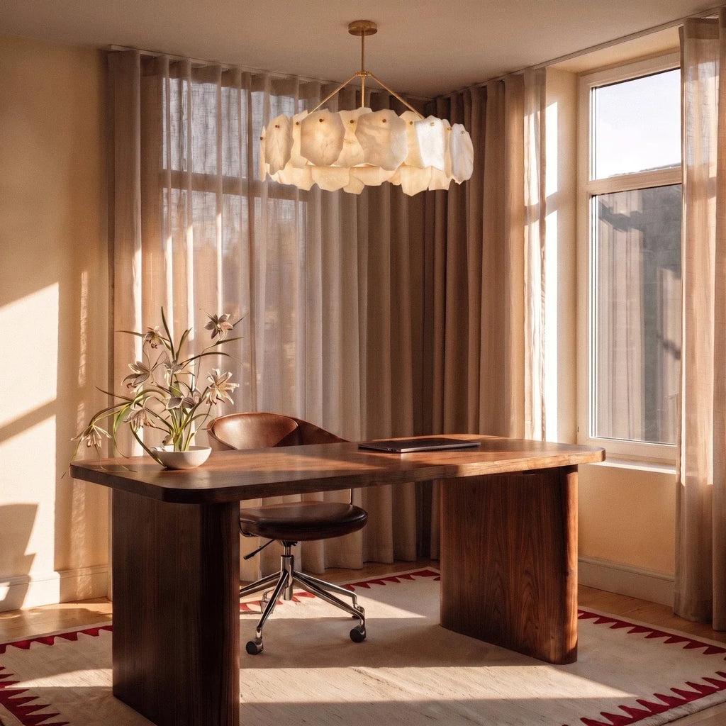 Clérachic round alabaster chandelier hung over a walnut desk with a leather chair, in a sunlit room with linen curtains.