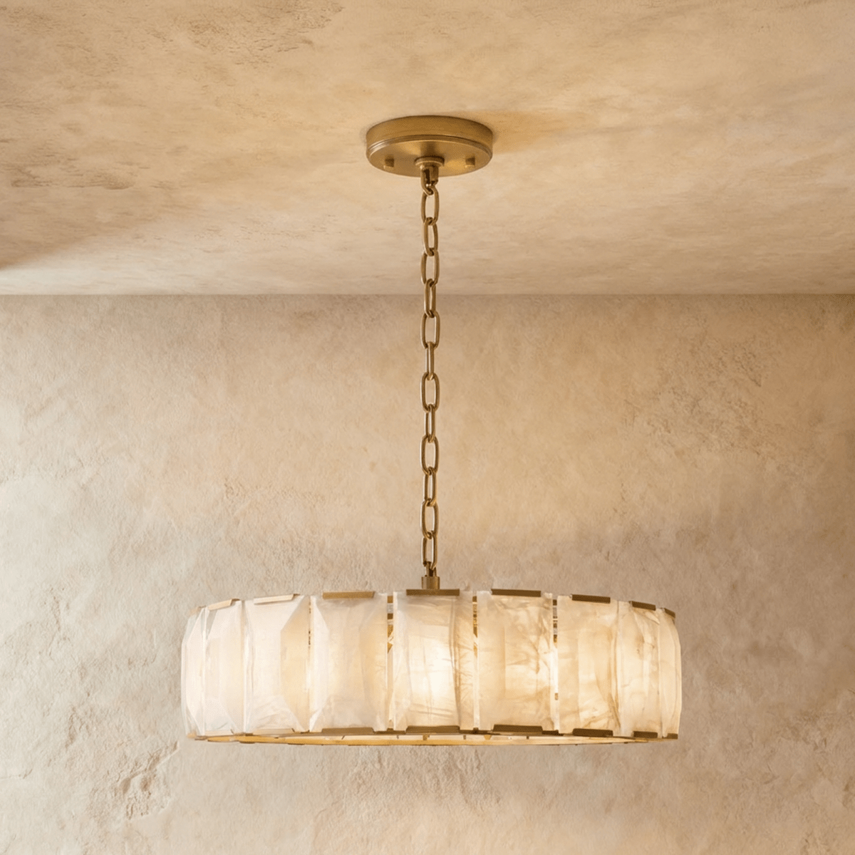 Clérachic round alabaster chandelier, 107 cm wide, with brass frame and chain, hung low in a plaster room