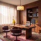 Clérachic alabaster drum chandelier in matte black hanging above a walnut desk in a sunlit study
