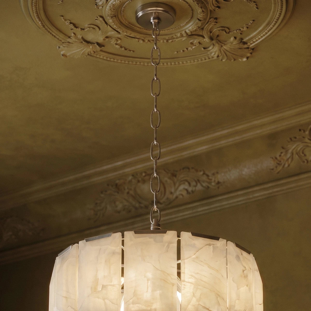 Clérachic polished steel chandelier chain and canopy beneath an ornate ceiling rose, over glowing alabaster panels