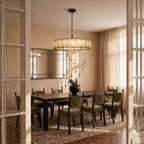 Clérachic wide matte black alabaster chandelier hung over a long dark dining table in a warm dining room