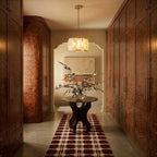 Clérachic brass alabaster drum chandelier lit in a hallway of burr walnut cabinets with a round table