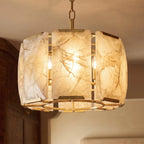 Close view of Clérachic alabaster panels in a brass frame, lit from inside to show warm amber veining