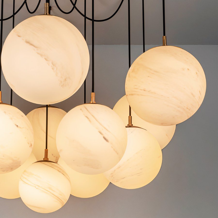 Clérachic close view of large veined globes lit warm, with a soft amber glow and brass cord fittings on black cords.