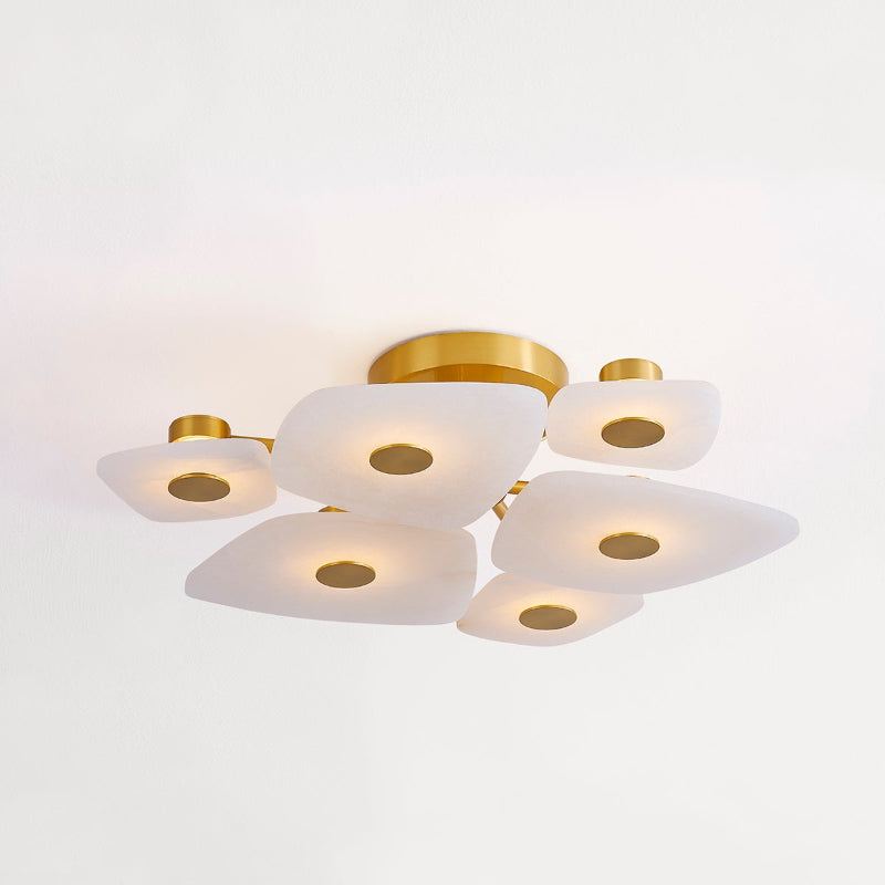 Clérachic Alabaster Cluster Ceiling Light in its round six-shade version, lit warm against a white living-room ceiling.