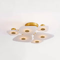 Round Clérachic Alabaster Cluster Ceiling Light seen at an angle, its brushed brass hub holding six backlit stone shades.