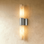 Clérachic 60 cm wall sconce with a glowing alabaster column and a mirror-bright polished nickel band on limewash.
