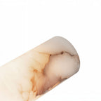 Close view of the Clérachic alabaster column, showing its soft cream body and warm amber and rose veining on white.
